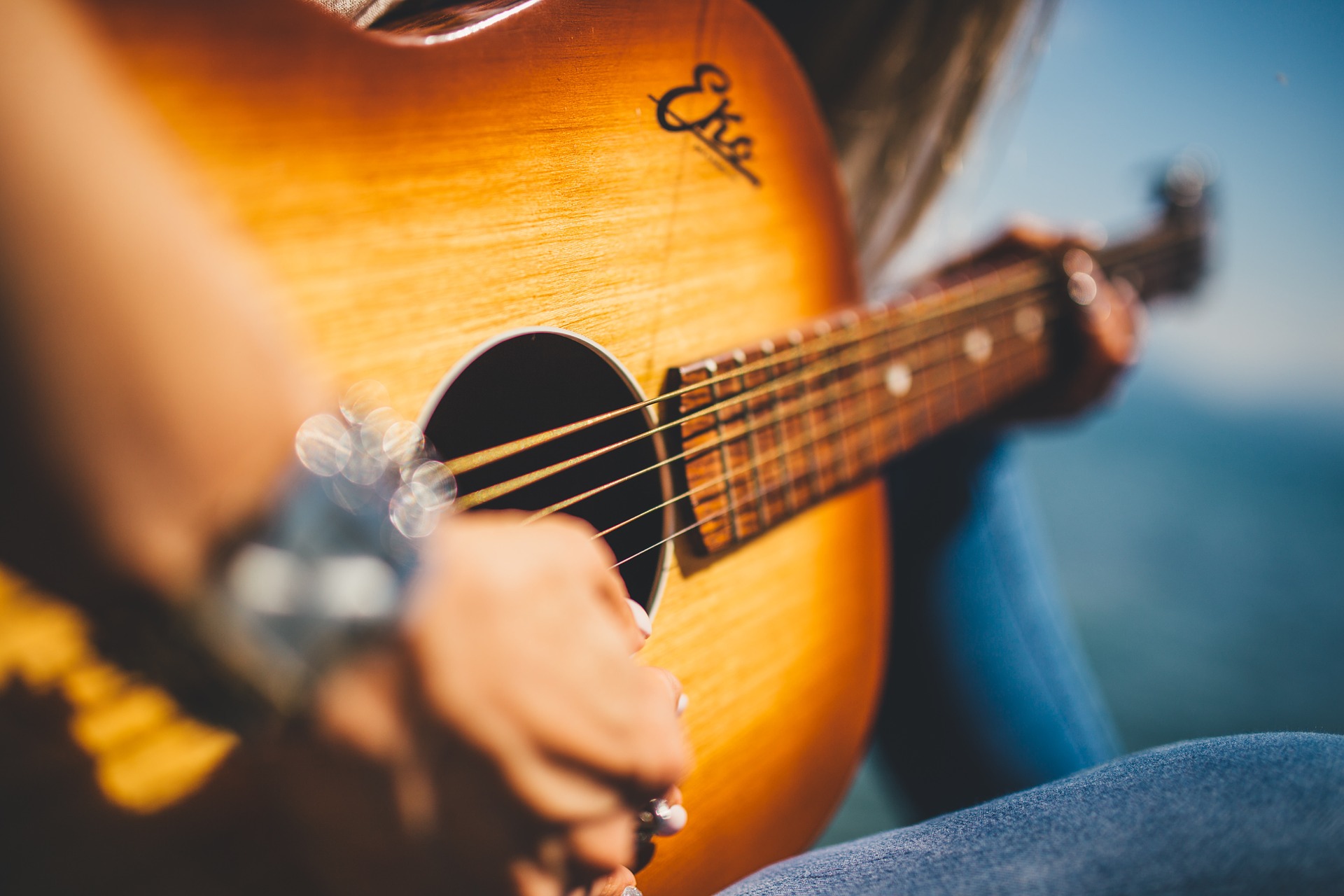 Close up of woman playing guitar from left hand with photo blur