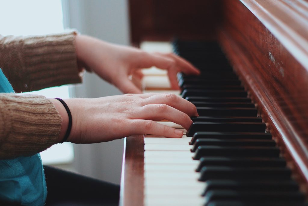 Close up of women's hands playing a red piano in living room