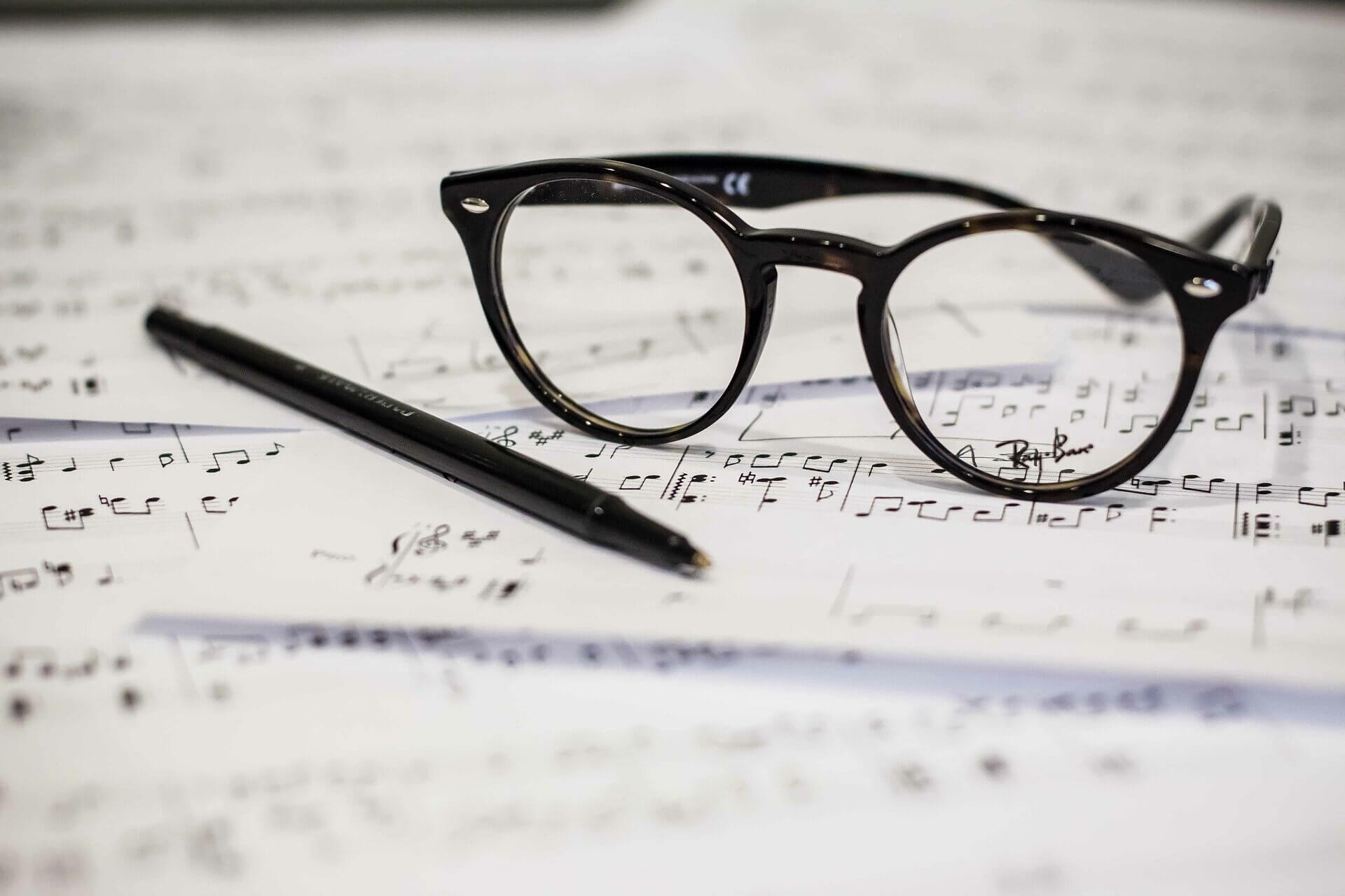 Glasses on sheet music with pen
